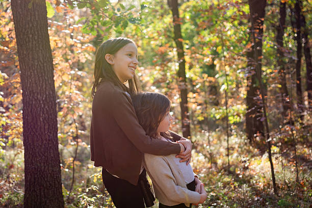 istock Sisters embracing in autumn forest enjoying nature 2244907658