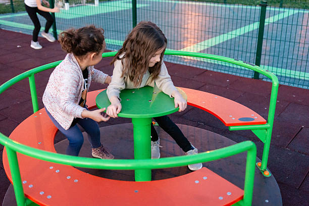 istock Girls playing on merry-go-round at playground 2244907942