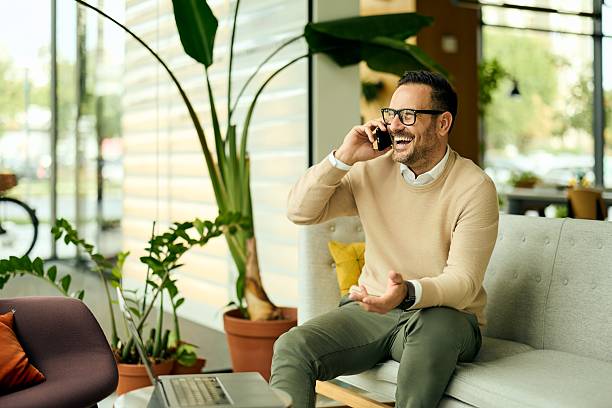 istock Happy Professional Man On Phone In Modern Office Lounge, Engaged And Smiling During Workday Break 2244909765