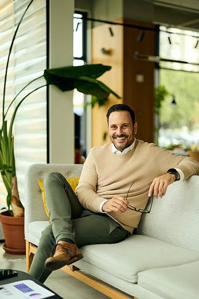 istock Confident Professional Man Relaxing On Sofa In Modern Office Setting With Glasses 2244909777