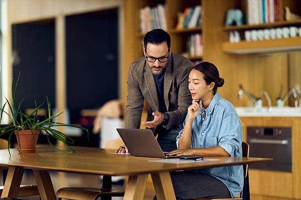 istock Collaborative Business Discussion At A Modern Kitchen Table With Laptop In Hand 2244909790