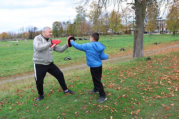 istock A man and a boy are training and practicing punches on training gloves 2244910446