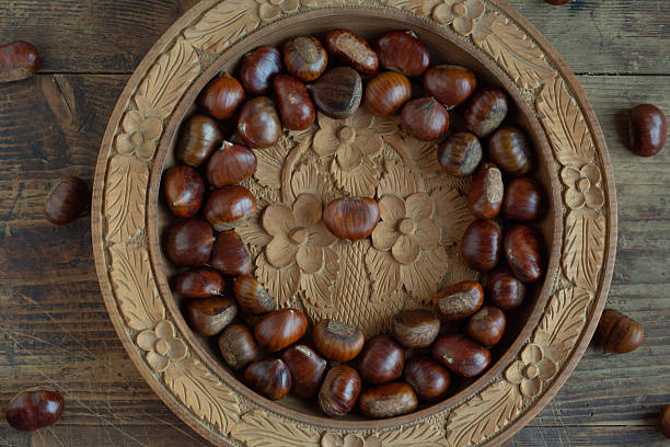 Fresh chestnuts on a wooden plate.