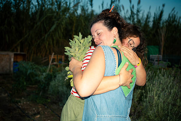 Twin sisters celebrate a harvest in a garden during evening hours, surrounded by greenery