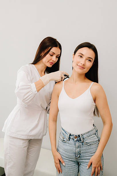 istock Dermatoscopic analysis aids in the detection of suspicious skin spots using dermatoscope during a clinical exam. Dermatologist Examining Girl Skin with Dermatoscope. 2244913510