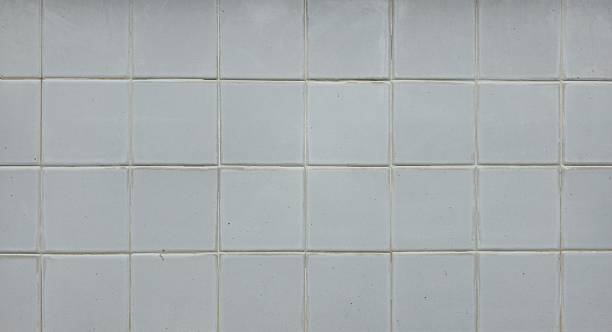 istock Old white tiled wall with stains, wall tiles, uneven tiles, and tile background texture. 2244916247