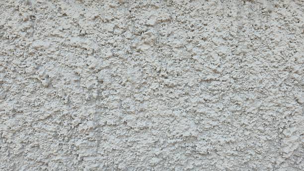 istock Rough white plaster wall with an uneven surface and natural imperfections. 2244916258
