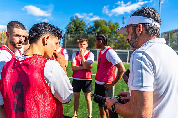 istock Soccer coach explaining strategy to players on field 2244916631