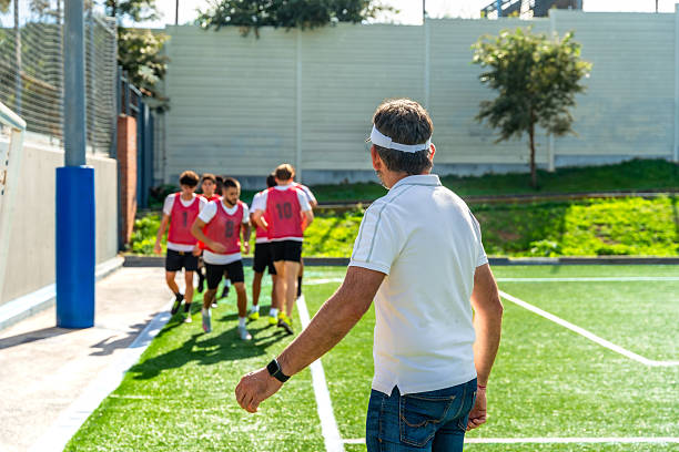 istock Coach watching young male athletes training on soccer field 2244917245