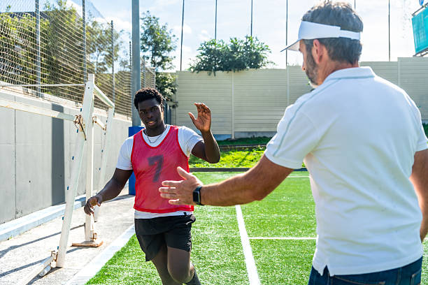 istock Football coach giving high five to young player 2244917285