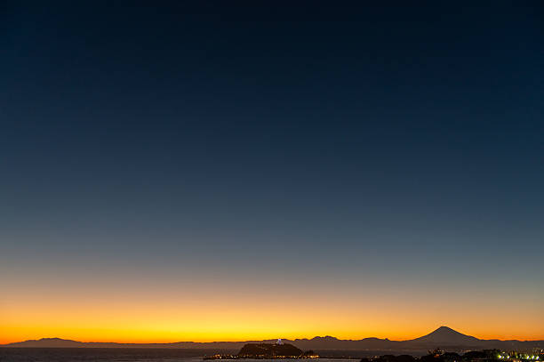 Coastline after sunset with a view of Enoshima and Mt. Fuji.
