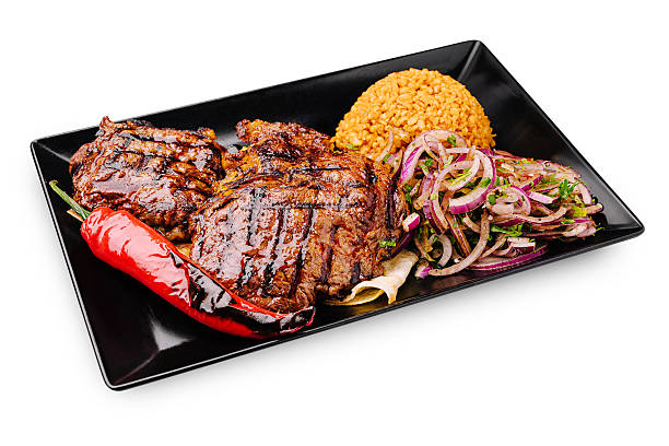 istock Sizzling grilled meat with rice and vegetables served on a black plate 2244918598