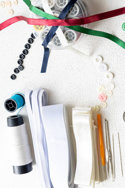 istock Cufflinks, Sewing Materials, Colorful Threads, and Scissors on a White Surface 2244921355