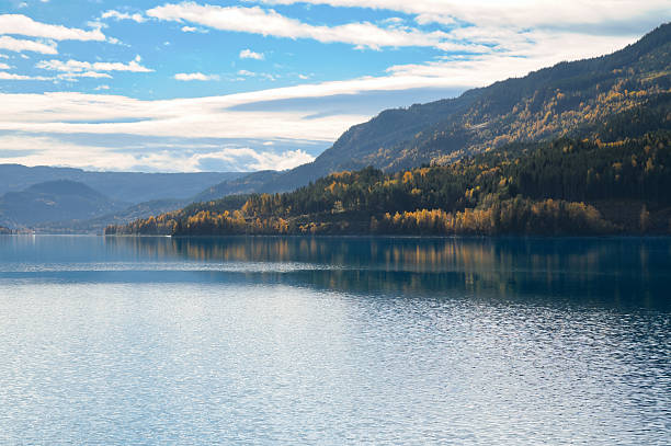 istock Autumnal lake with reflection and colorful forest under blue sky 2244921693