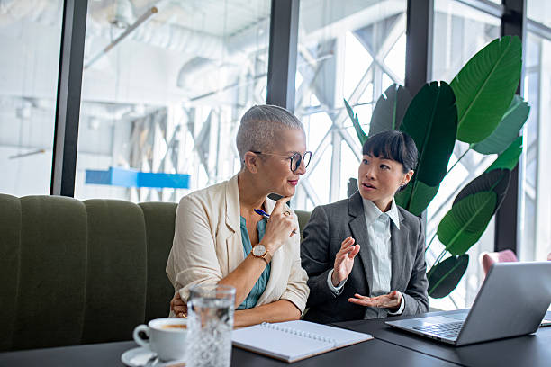 istock Confident female colleagues working together on laptop in stylish workspace 2244922020