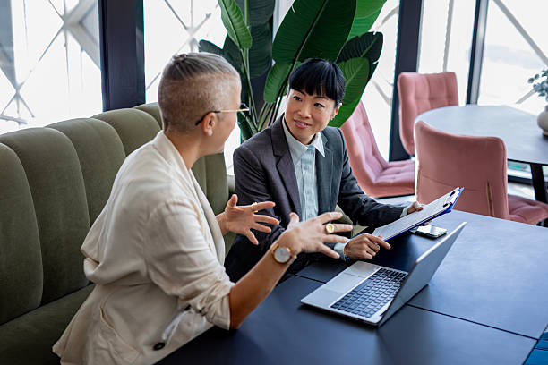istock Confident female colleagues working together on laptop in stylish workspace 2244924094