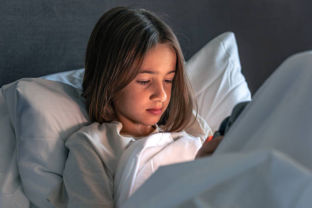 istock Girl gazing at smartphone under duvet. Evening scroll. 2244924190