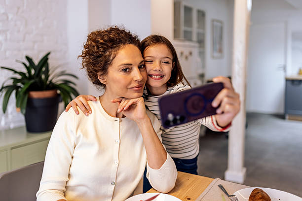 istock Mother and daughter taking selfie together at home kitchen table 2244924898