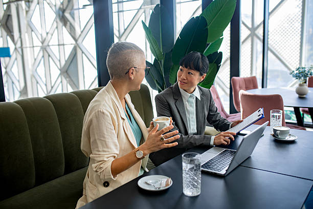 istock Confident female colleagues working together on laptop in stylish workspace 2244925754