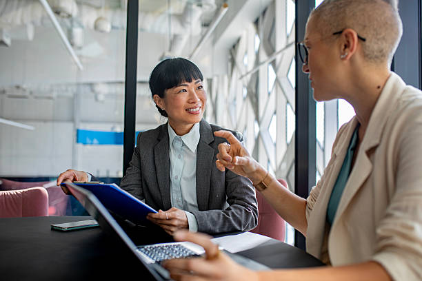 istock Confident female colleagues working together on laptop in stylish workspace 2244925864