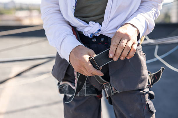 istock Construction worker puts on a safety harness on the roof of a building. 2244926340