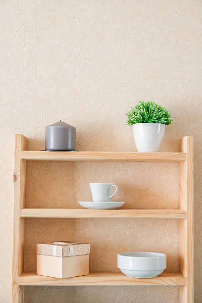 istock candle, decorative flower, mug, bowl, gift box on shelves 2244926402
