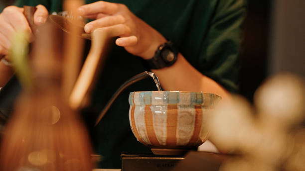 istock Pouring hot water from a kettle, preparing for green tea brewing 2244928827