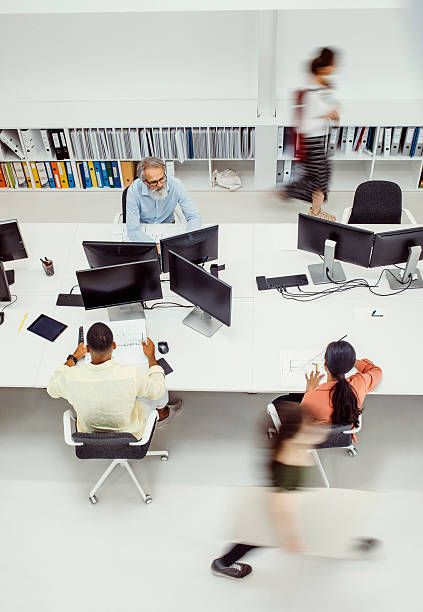 istock Diverse Professionals Collaborating in Busy Architecture Biro with Multiple Workstations 2244929328