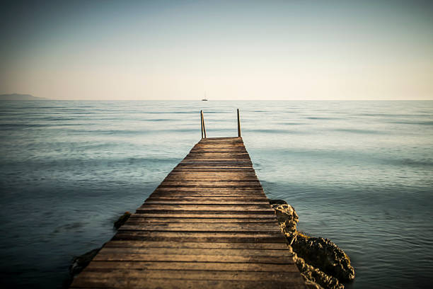 A rustic wooden dock at the seashore with a bit of a dreamy atmosphere