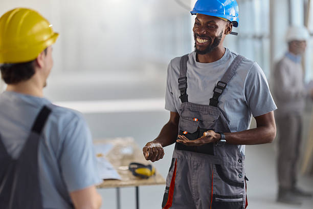 istock Happy black worker talking to his colleague at construction site. 2244931196