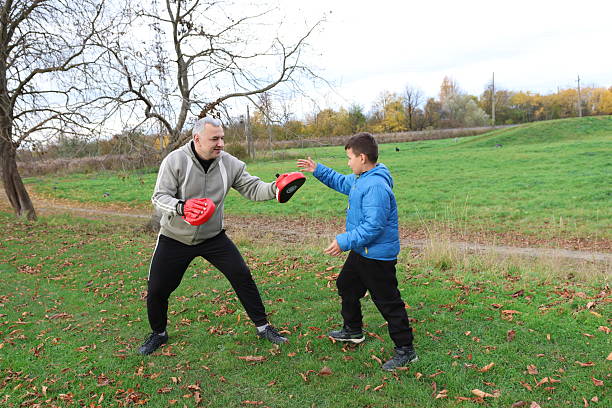 istock A man and a boy are training and practicing punches on training gloves 2244932630