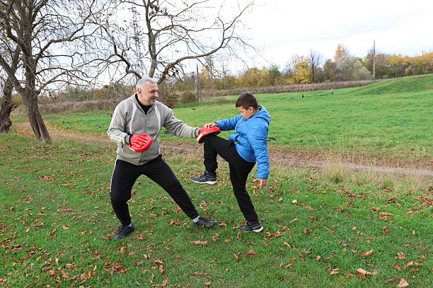 istock A man and a boy are training and practicing punches on training gloves 2244932822
