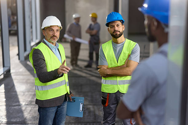 istock Male inspector giving instructions to his workers at construction site. 2244932868