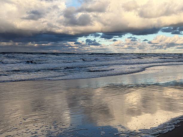 Clouds, waves and seagulls at the North Sea coast of Julianadorp Netherlands.