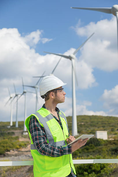 istock Engineer Man Using Digital Tablet for Wind Turbine Inspection at a Wind Farm for Renewable Energy Projects 2244933660