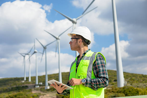 istock Engineer Man Using Digital Tablet for Wind Turbine Inspection at a Wind Farm for Renewable Energy Projects 2244933667