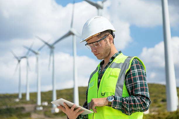 istock Engineer Man Using Digital Tablet for Wind Turbine Inspection at a Wind Farm for Renewable Energy Projects 2244933686