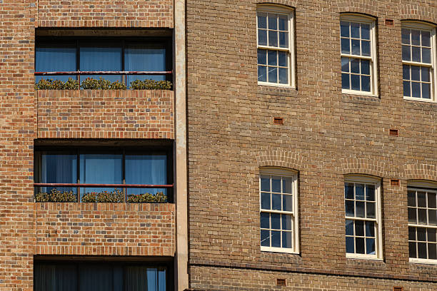 Balconies and windows in a brick building on a sunny day.