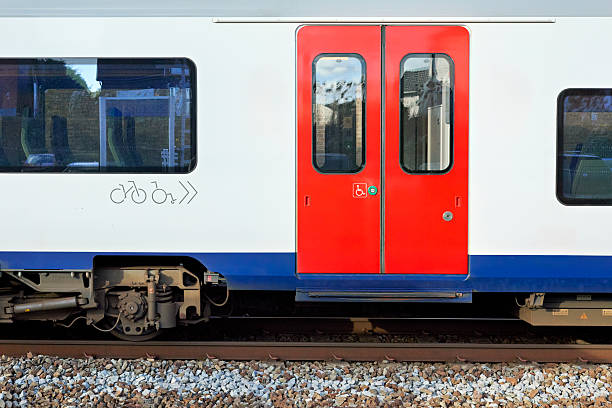 istock Train carriage with bright red doors, windows, and symbols for bicycle and wheelchair access, on tracks, showcasing modern public transport design and accessibility features. 2244937065