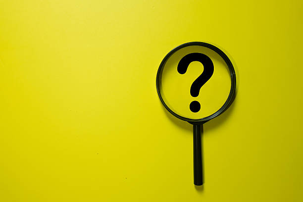 istock Magnifying glass focusing on a black question mark icon, symbolizing searching for answers, investigation, and problem-solving on a yellow background. 2244937231