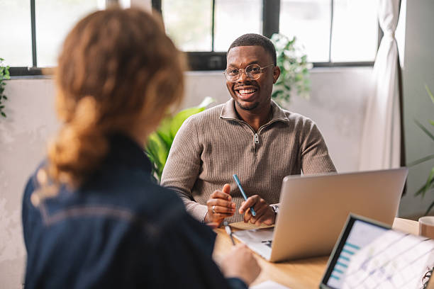 istock Smiling Professional Discussing Ideas with Colleague 2244937384