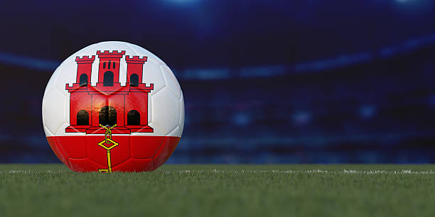 Close-up of a football and a player wearing red socks (symbol image)