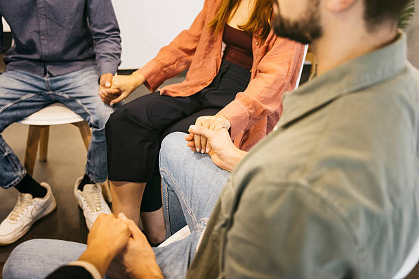 istock Diverse group of people holding hands during therapy session 2244942948