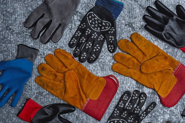 istock Set of various protective work gloves in different colors and materials placed on a metallic textured surface. Concept of safety equipment, industrial protection, and construction accessories. 2244945686