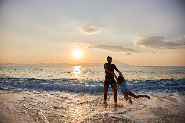Father and son playing together at sunset.