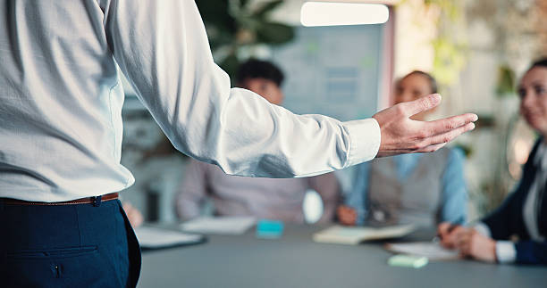 istock Business person, hands and presentation with team in office for brainstorming or project planning. Back view, employee or speaker with group for meeting, staff training or discussion in conference 2244948269