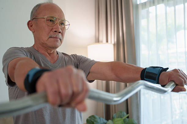 istock Asian senior man lifting barbell at home for strength exercise 2244948896