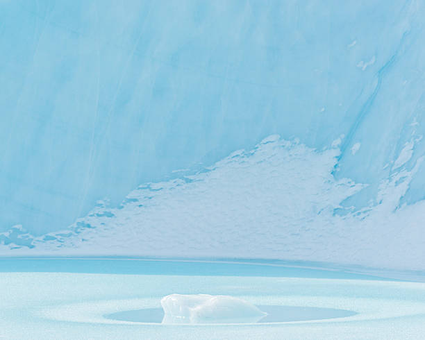 istock Ice surface reflecting soft blue tones with a small piece of ice floating in the center 2244958838