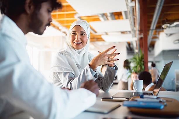 istock Multicultural Colleagues Smiling and Working Together on a Laptop in a Bright Modern Office 2244958925