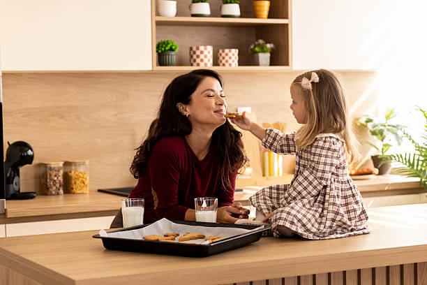 istock Daughter feeding her mother with a cookie 2244960600